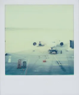 A color Polaroid photograph an airplane, preparing for boarding, sitting on the asphalt at the airport in Seoul, South Korea.